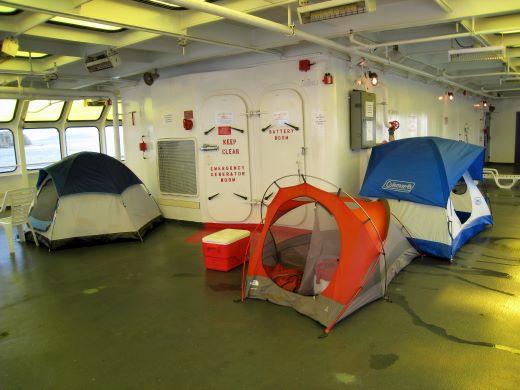 04-pr-k-tenters.jpg - Pitching  a tent for a long overnight sail on the stern are accepted and commonplace.  An air mattress or some type of padding is a requirement on the hard deck surface.