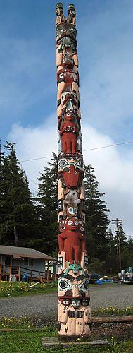 pow-totem-hydaburg1.jpg - A colorful totem pole from Hydaburg, AK.  There are two men sitting on top with top hats, meaning unknown.  The carving may seem fanciful but each figure has a meaning and, put together, has a message, unknown to us.