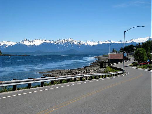 13-petersburg-road-north.jpg - Like all the islands with the Inside Passage, paved roadways are limited to around town.  This stretch of Mitkof Highway is called Sandy Beach Road and stretches along Frederick Sound.  You can just make out Horn Mountain, with its three cone shaped peaks.  It is reported Humpback whales can be seen in the Sound during the summer months.